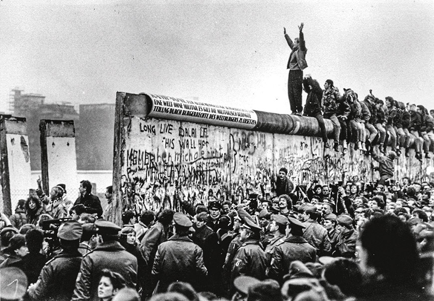 11/12/89 - - The opening of the Berlin Wall at Potsdamer Platz. East Germans pour through the newly opened wall, as a West Berliner cheers them on from on top. - Photo By Carol Guzy/TWP (Photo by Carol Guzy/The The Washington Post via Getty Images)